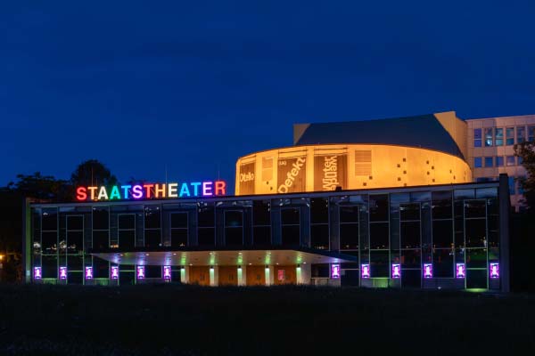 Bild vom Staatstheater in Kassel, dessen Buchstaben in Regenbogenfarben gezeigt werden